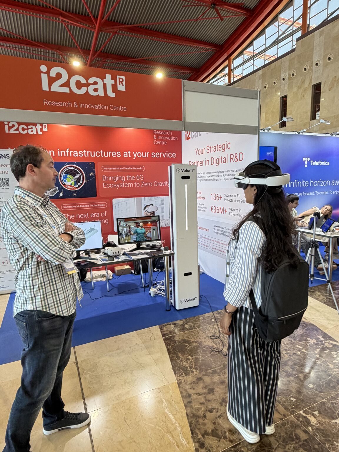 A visitor wearing a mixed reality headset in front of a capture unit at the i2CAT booth