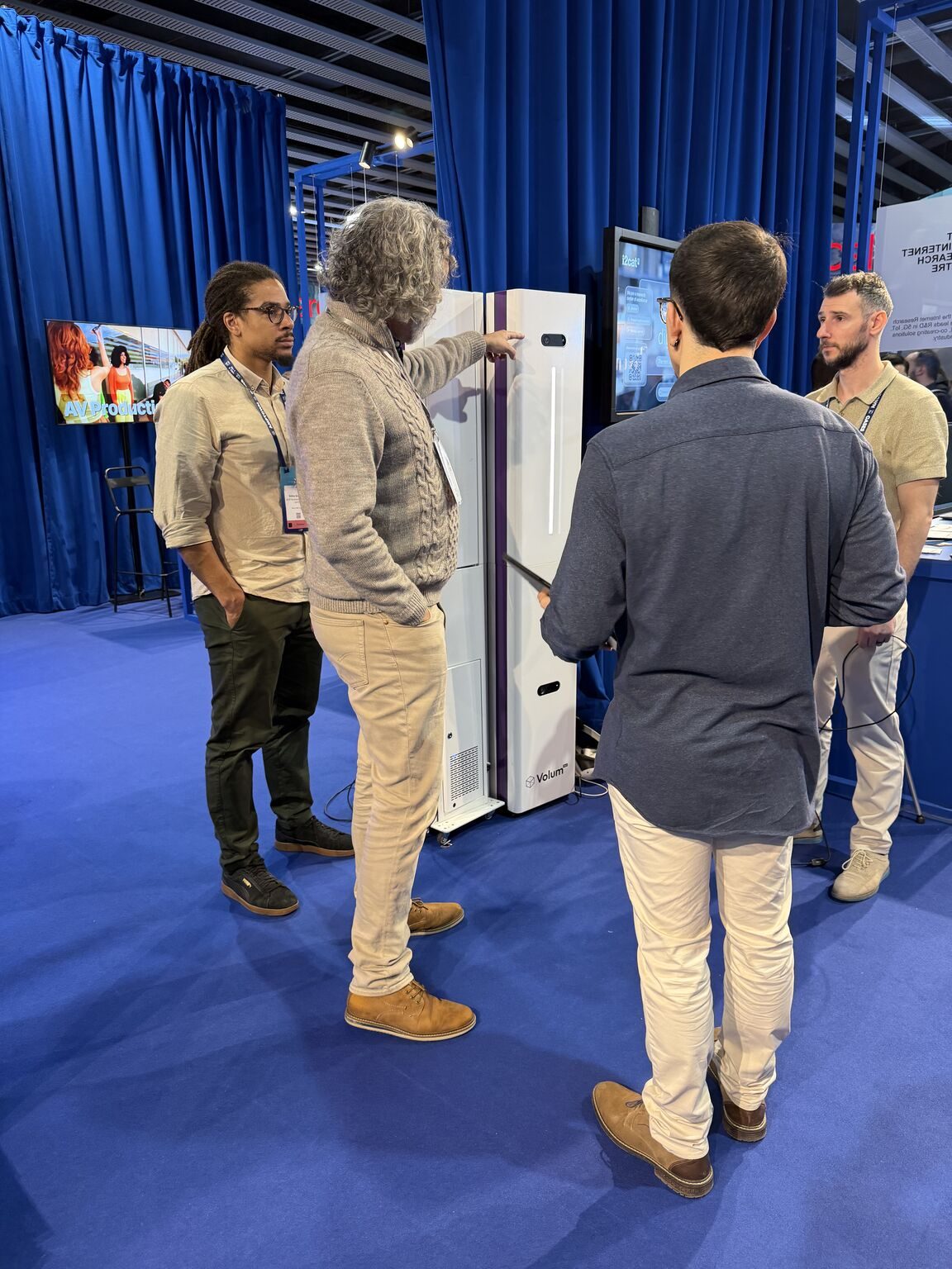 Attendees gathered around HoloTotem units at the Volum booth